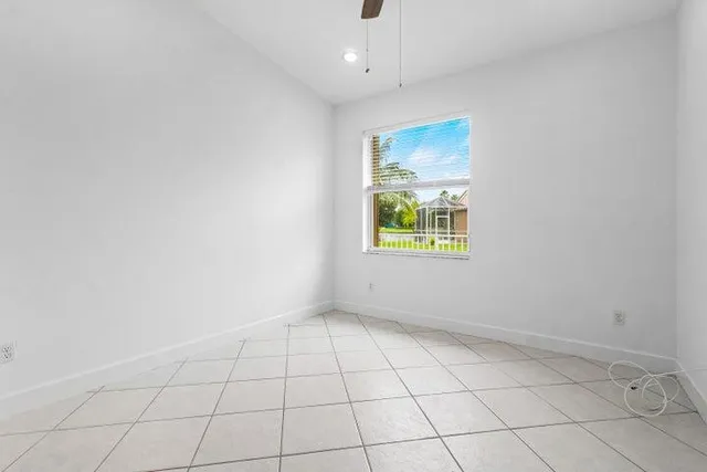 an empty room with a window and a ceiling fan