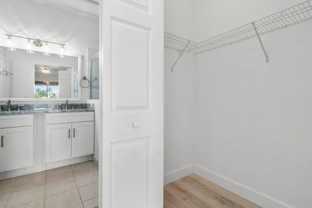 a bathroom with a granite countertop sink a mirror and shower