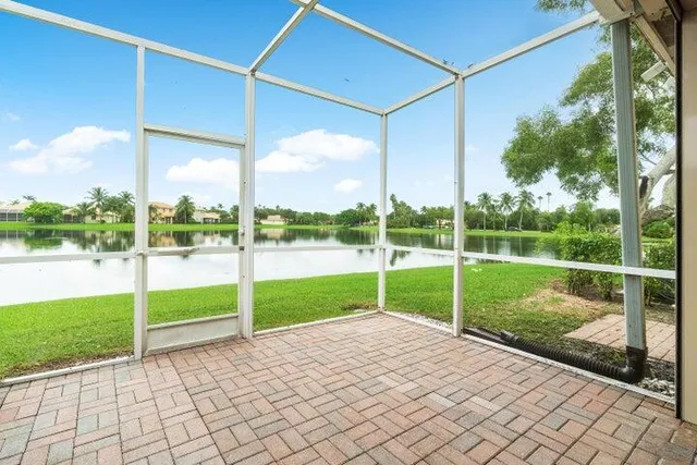 a view of a house with a yard and a large tree