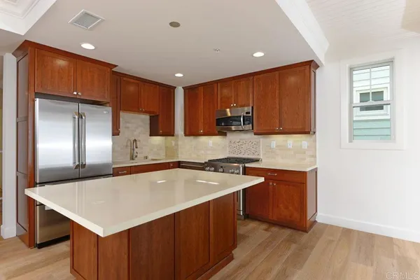 a kitchen with stainless steel appliances granite countertop a sink a microwave and wooden cabinets