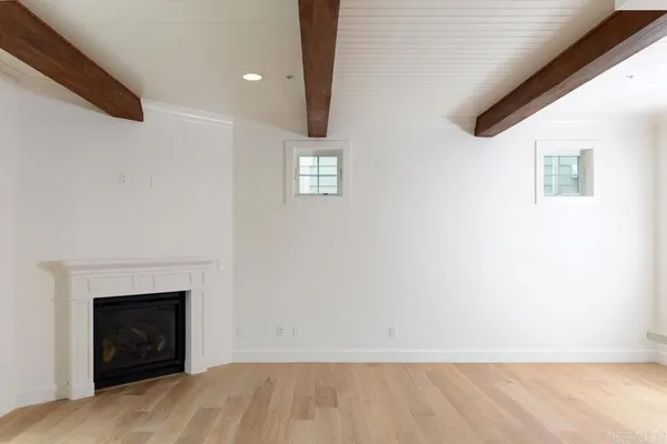 a view of an empty room with a fireplace and a window