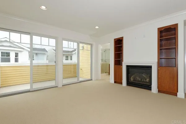 an empty room with windows and fireplace