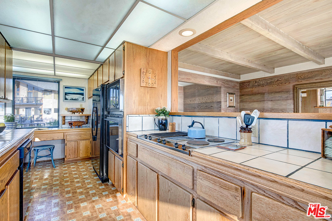 249 Fowling Street Playa del Rey, CA 90293 - Photo 13 of 40 a kitchen with stainless steel appliances kitchen island granite countertop a sink stove and refrigerator