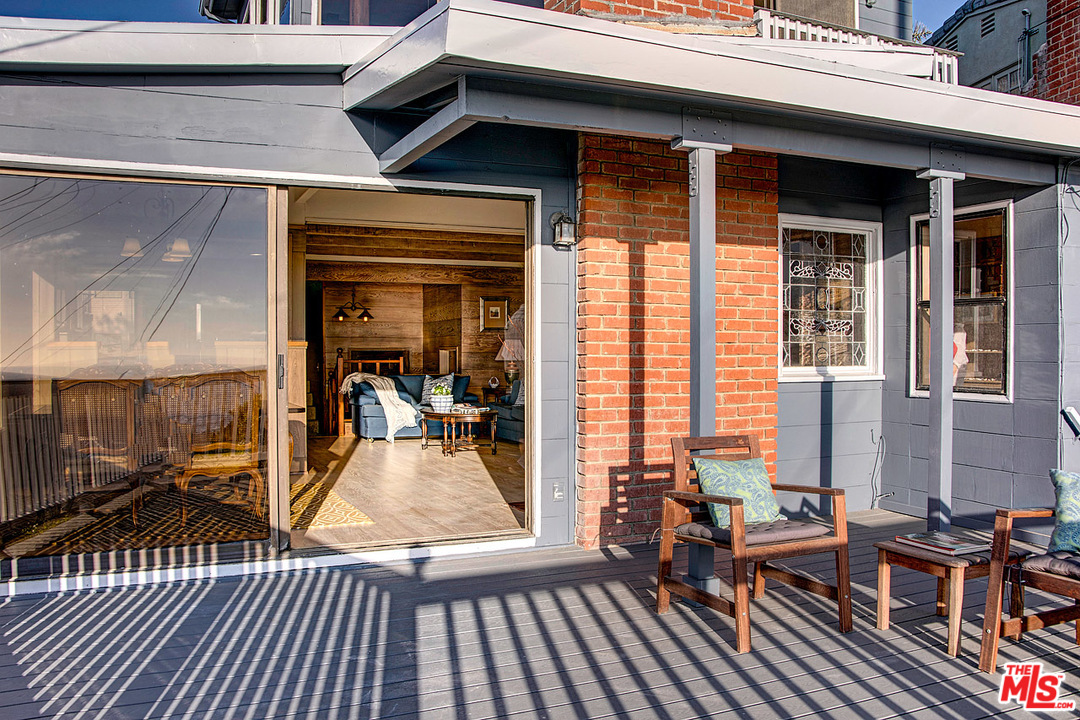 249 Fowling Street Playa del Rey, CA 90293 - Photo 35 of 40 a view of a patio with table and chairs with wooden floor and floor to ceiling window