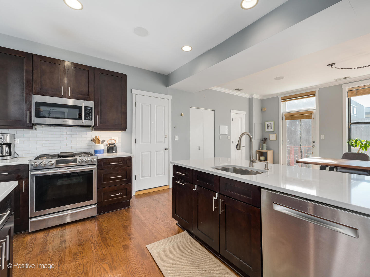 2075 North Oakley Avenue, Unit 3F Chicago, IL 60647 - Photo 7 of 24 a kitchen with stainless steel appliances granite countertop a sink a stove a microwave and wooden cabinets