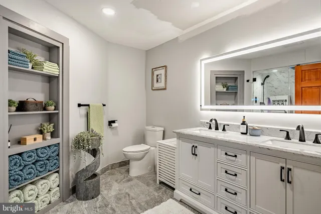 a bathroom with a double vanity sink toilet and shower