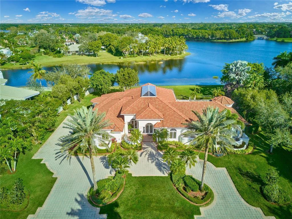 an aerial view of a house with a yard and lake view