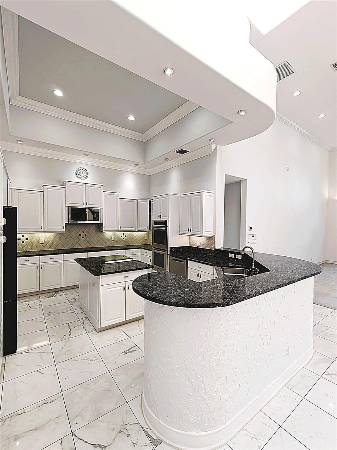 2939 Paddock Lane Weston, FL 33331 - Photo 5 of 86 a large kitchen with a large counter top stainless steel appliances and cabinets