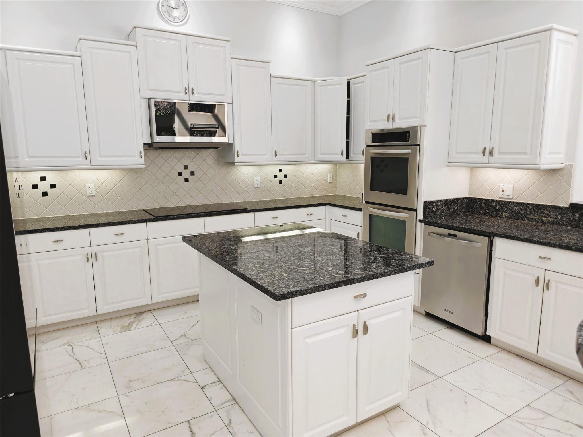 2939 Paddock Lane Weston, FL 33331 - Photo 6 of 86 a kitchen with kitchen island granite countertop white cabinets white stainless steel appliances with a sink and dishwasher