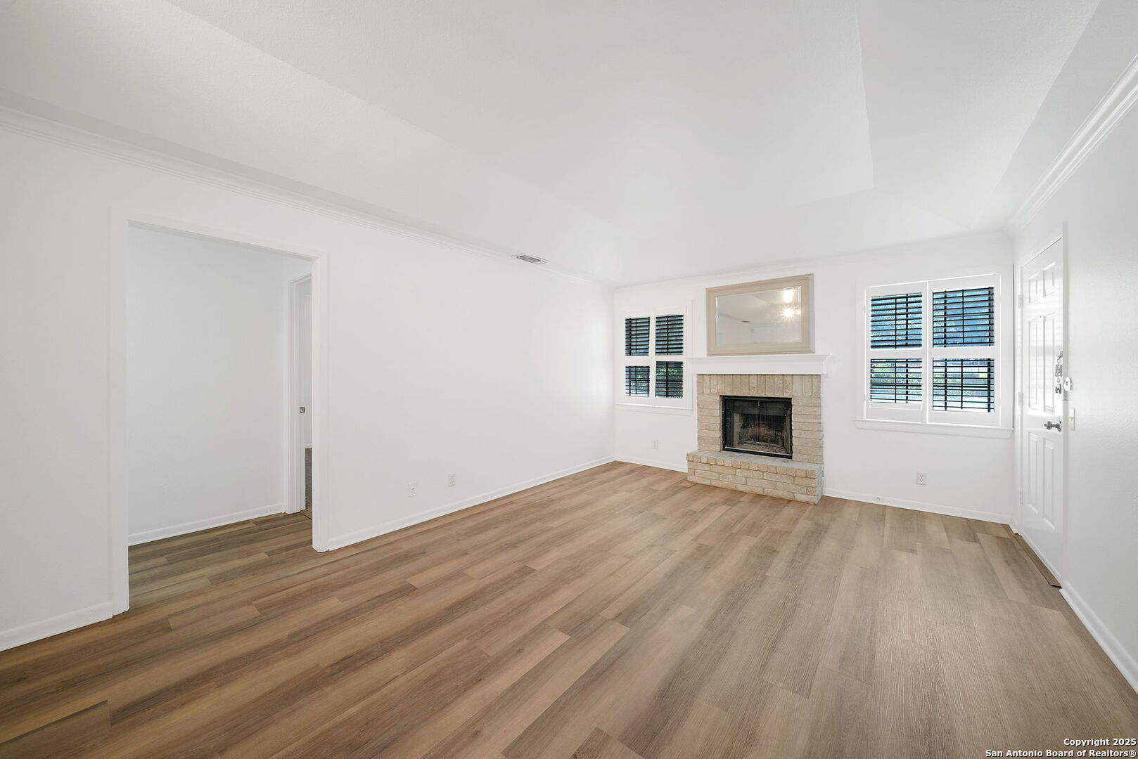 8415 Fredericksburg Road, Unit 704 San Antonio, TX 78229 - Photo 10 of 30 an empty room with wooden floor fireplace and windows