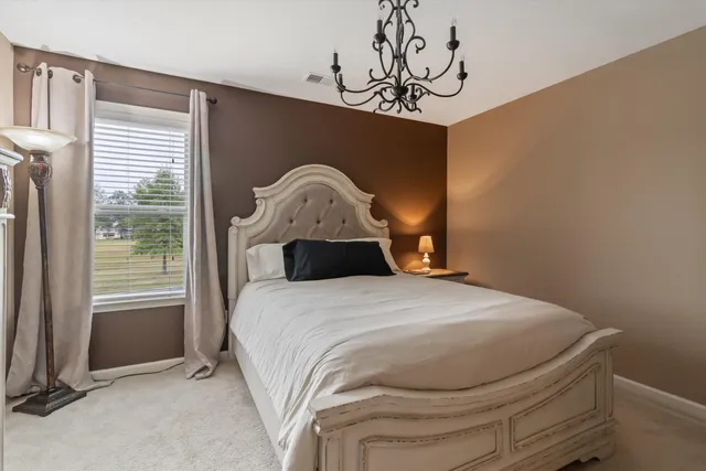 a bed sitting in a bedroom next to a window