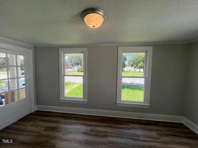 an empty room with wooden closet and windows