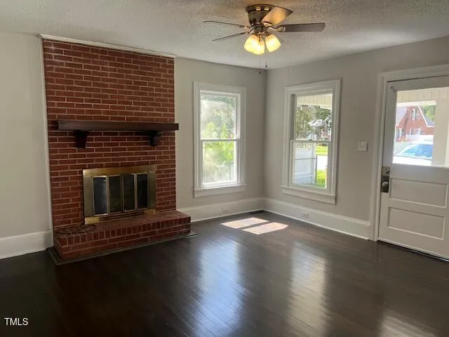a living room with wooden floors and a fireplace