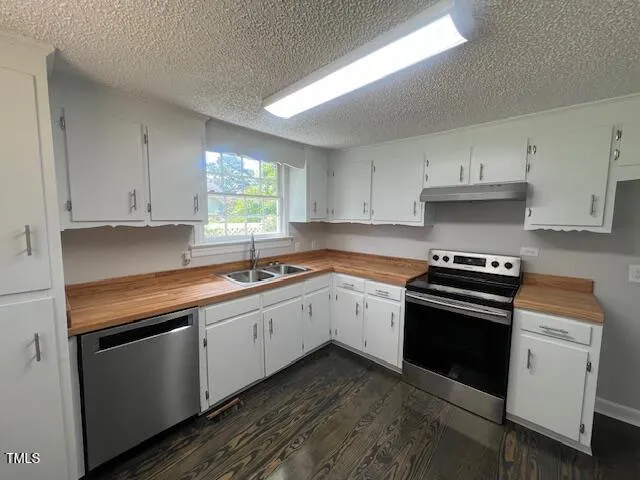 a kitchen with granite countertop white cabinets and appliances