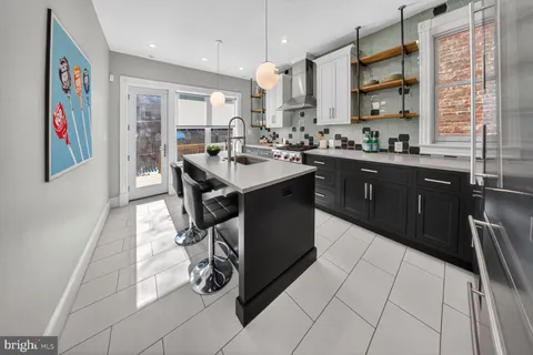 a kitchen with kitchen island stainless steel appliances a sink stove and refrigerator