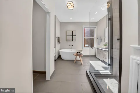 a bathroom with a tub sink and mirror