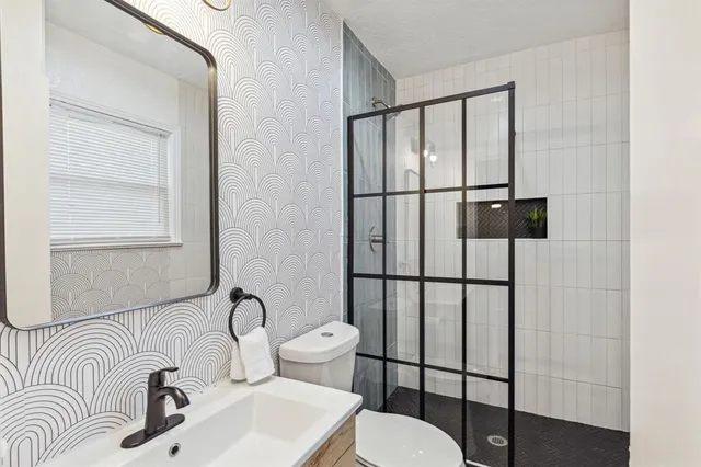 a bathroom with a sink toilet and mirror