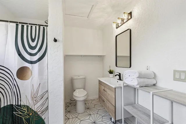 a bathroom with a sink mirror vanity and toilet