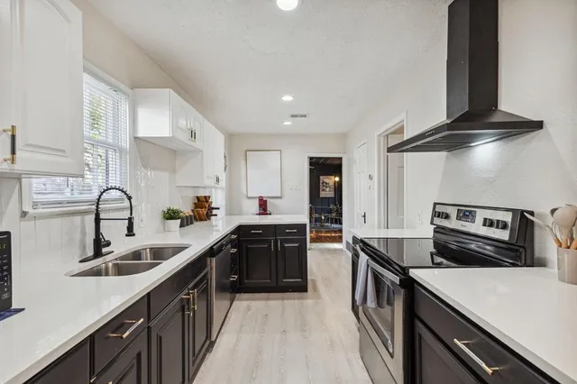 a kitchen with stainless steel appliances a sink stove and cabinets