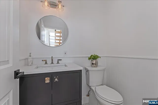 a bathroom with a toilet a sink and mirror