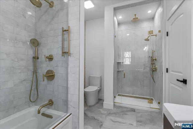 a bathroom with a granite countertop sink a toilet and shower