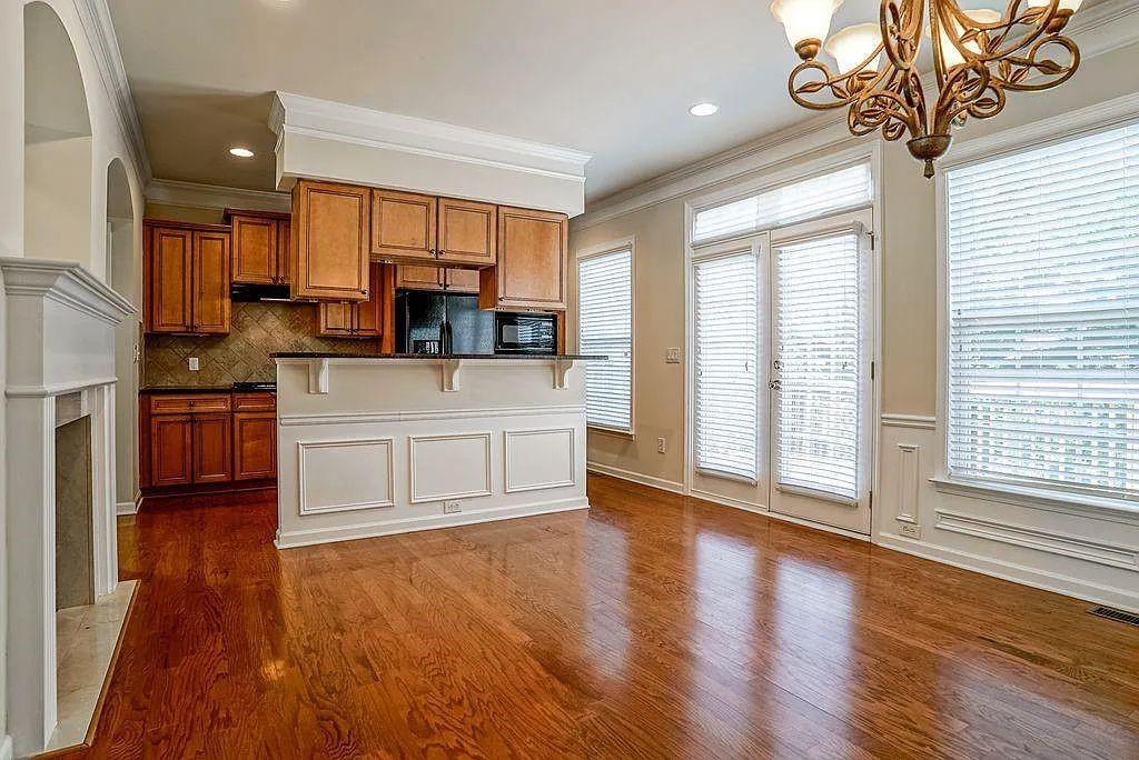 6120 Joybrook Road Duluth, GA 30097 - Photo 12 of 30 a large kitchen with stainless steel appliances granite countertop a stove top oven a sink dishwasher a dining table and chairs with wooden floor