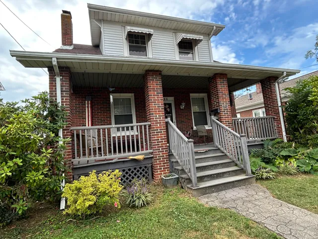 a view of a house with wooden deck and a yard