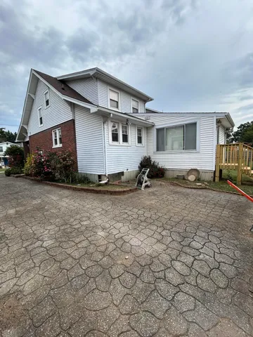 a view of a house with backyard and trees