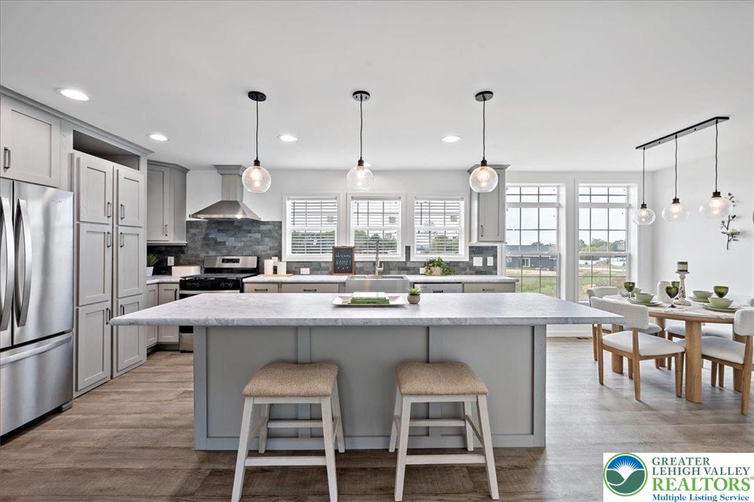 3983 Hastings Road Walnutport, PA 18088 - Photo 16 of 39 a kitchen with stainless steel appliances granite countertop a stove top oven a refrigerator a sink and chairs
