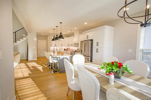 a dining room filled chandelier and kitchen view
