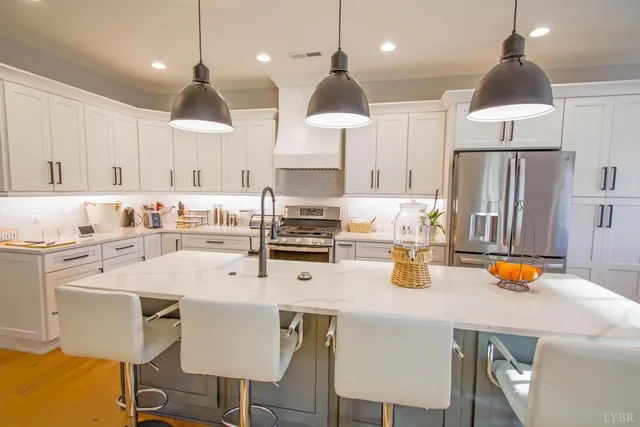 a kitchen with a sink a stove and chairs with wooden floor