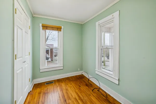 a view of a hallway with wooden floor and closet