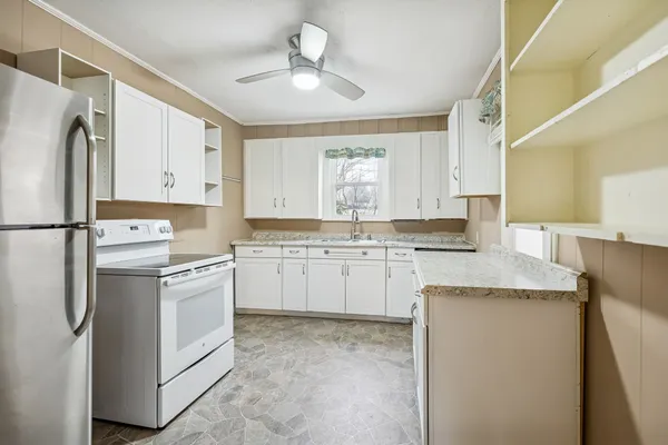 a kitchen with white cabinets and white appliances