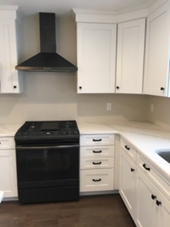 67 Fieldstone Lane, Unit 2 Fall River, MA 02720 - Photo 3 of 6 a kitchen with white cabinets and a stove