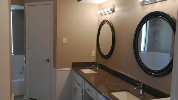 a bathroom with a granite countertop toilet a sink and a mirror