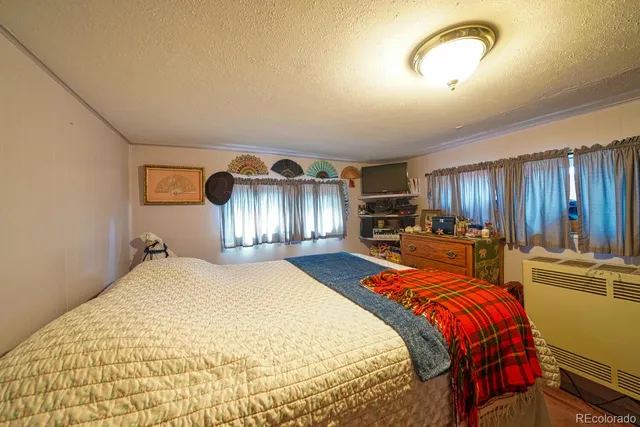 a bed room with a bed and a view of kitchen
