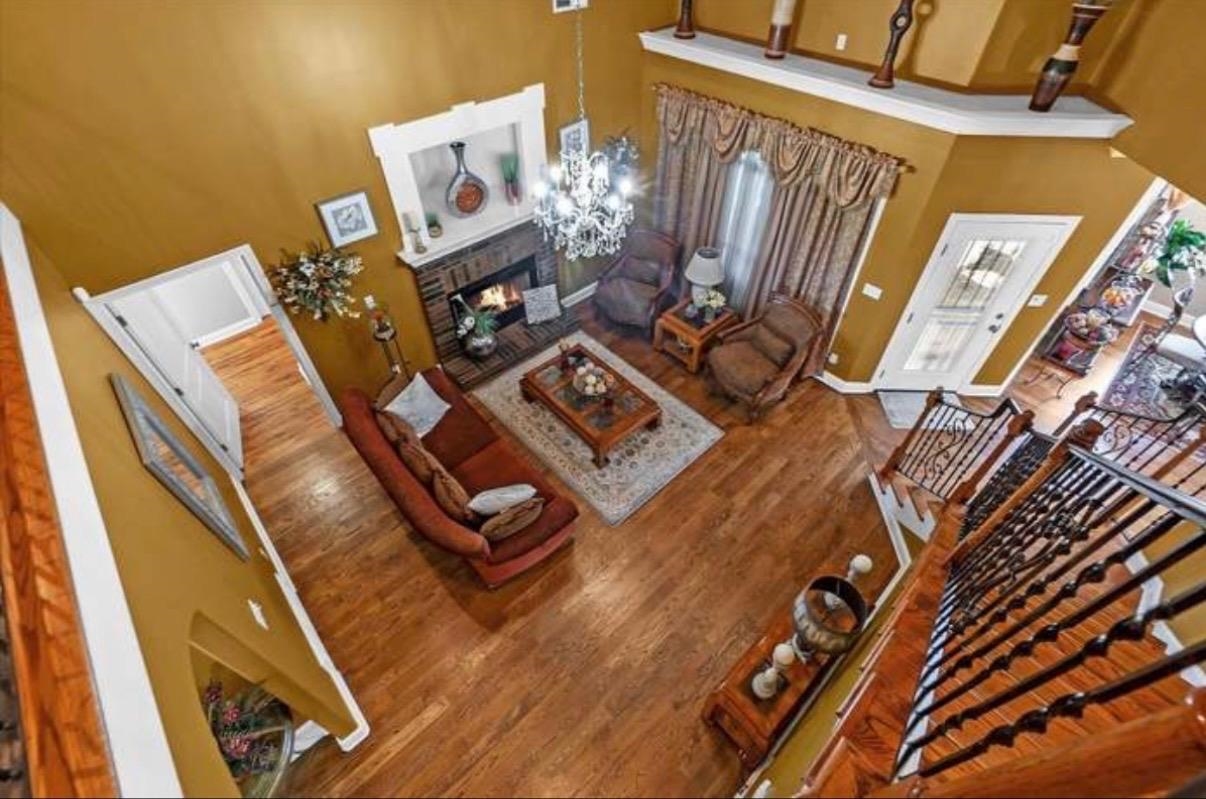 7284 Bucknell Road Millington, TN 38053 - Photo 13 of 24 Hardwood flooring, wrought iron stair railing, fireplace with wood mantel, decorative chandelier, and recessed ceiling