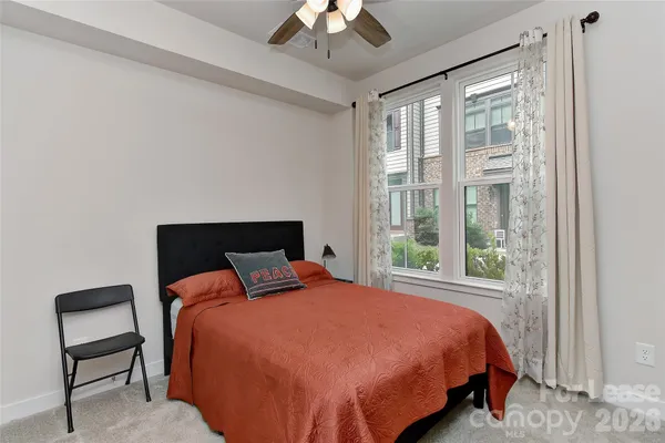 a bedroom with a bed and a large window