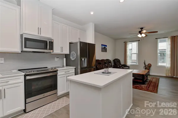 a kitchen with stainless steel appliances a stove refrigerator sink and microwave