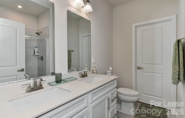 a bathroom with a toilet sink vanity and mirror