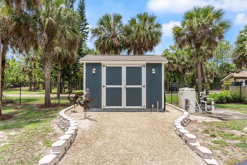 1820 19th Street Southwest Naples, FL 34117 - Photo 23 of 31 a front view of a house with a garden and trees