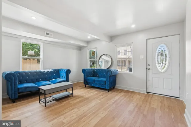 a living room with furniture and a wooden floor