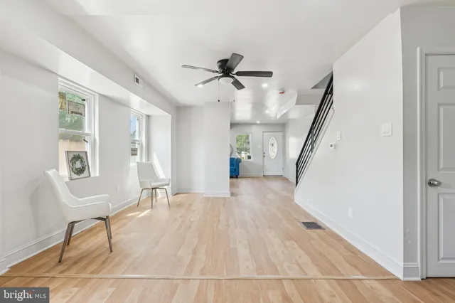 a view of an empty room with kitchen and a window