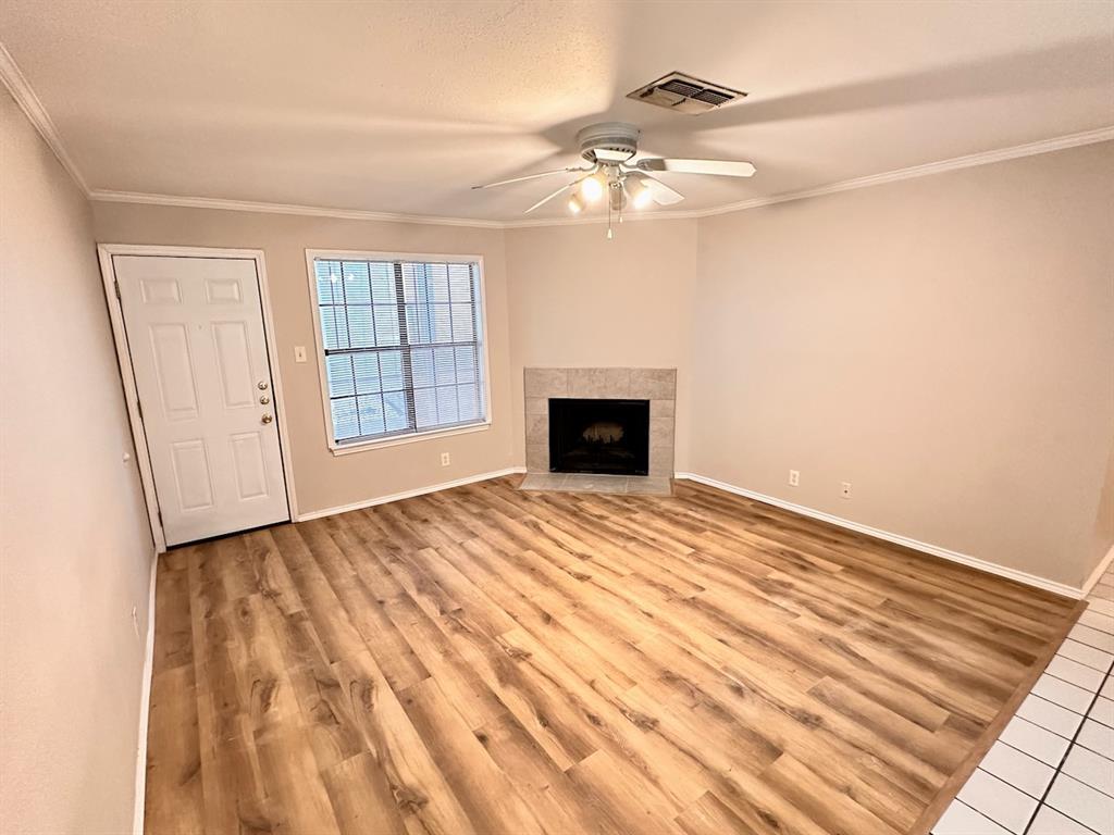 2215 Post Road, Unit 1010 Austin, TX 78704 - Photo 3 of 25 an empty room with a fireplace and chandelier fan