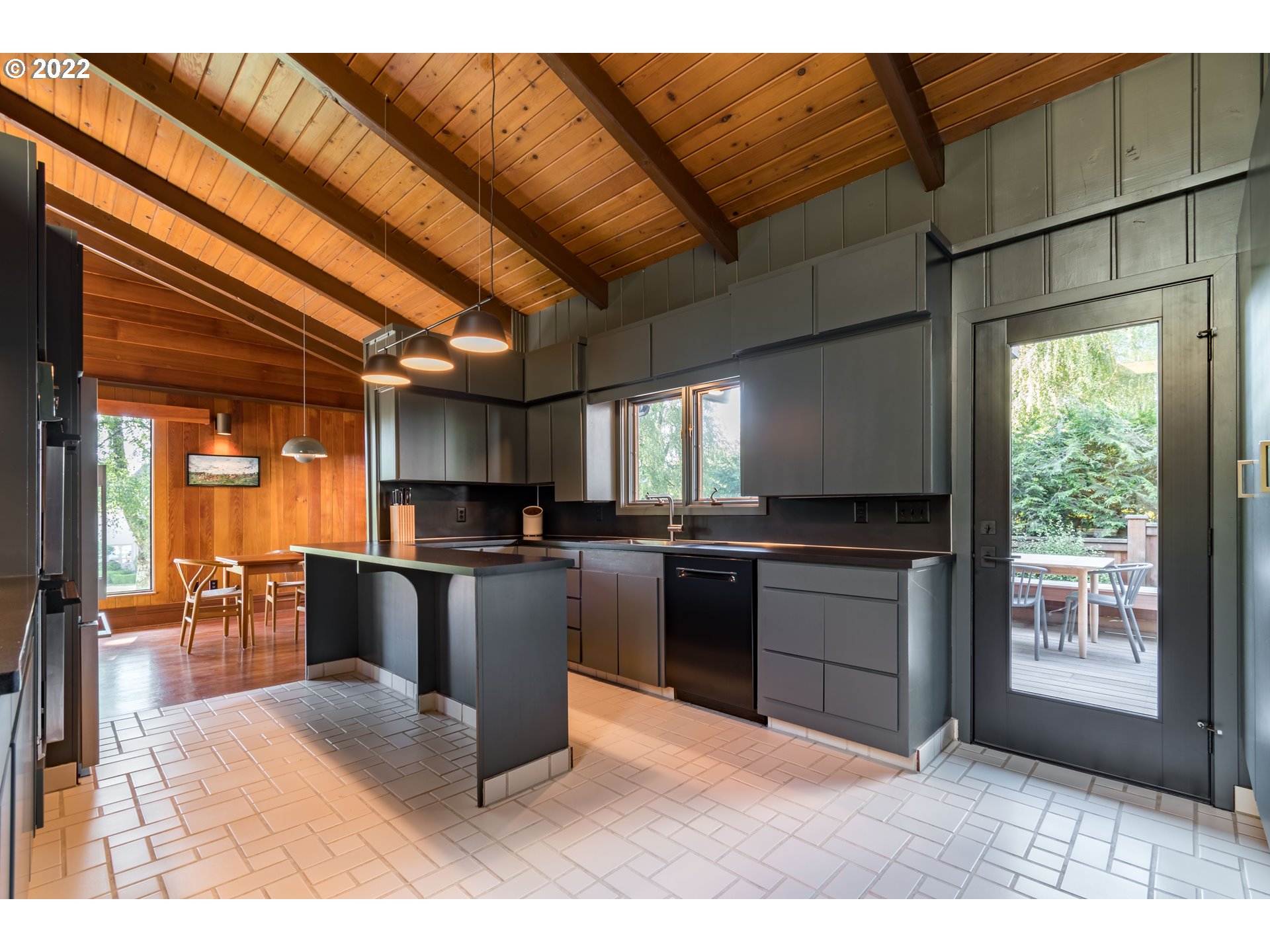 2000 University Street Eugene, OR 97403 - Photo 9 of 32 a kitchen with stainless steel appliances kitchen island granite countertop a refrigerator a sink dishwasher a dining table and chairs with wooden floor
