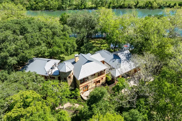 an aerial view of a house with a yard and lake view