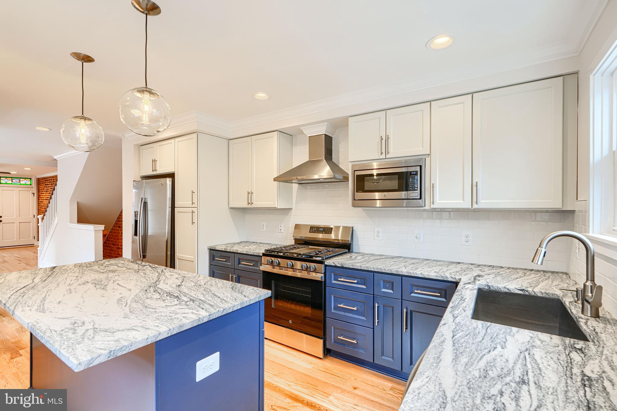 719 South Robinson Street Baltimore, MD 21224 - Photo 13 of 31 a kitchen with granite countertop stainless steel appliances a stove sink microwave and cabinets