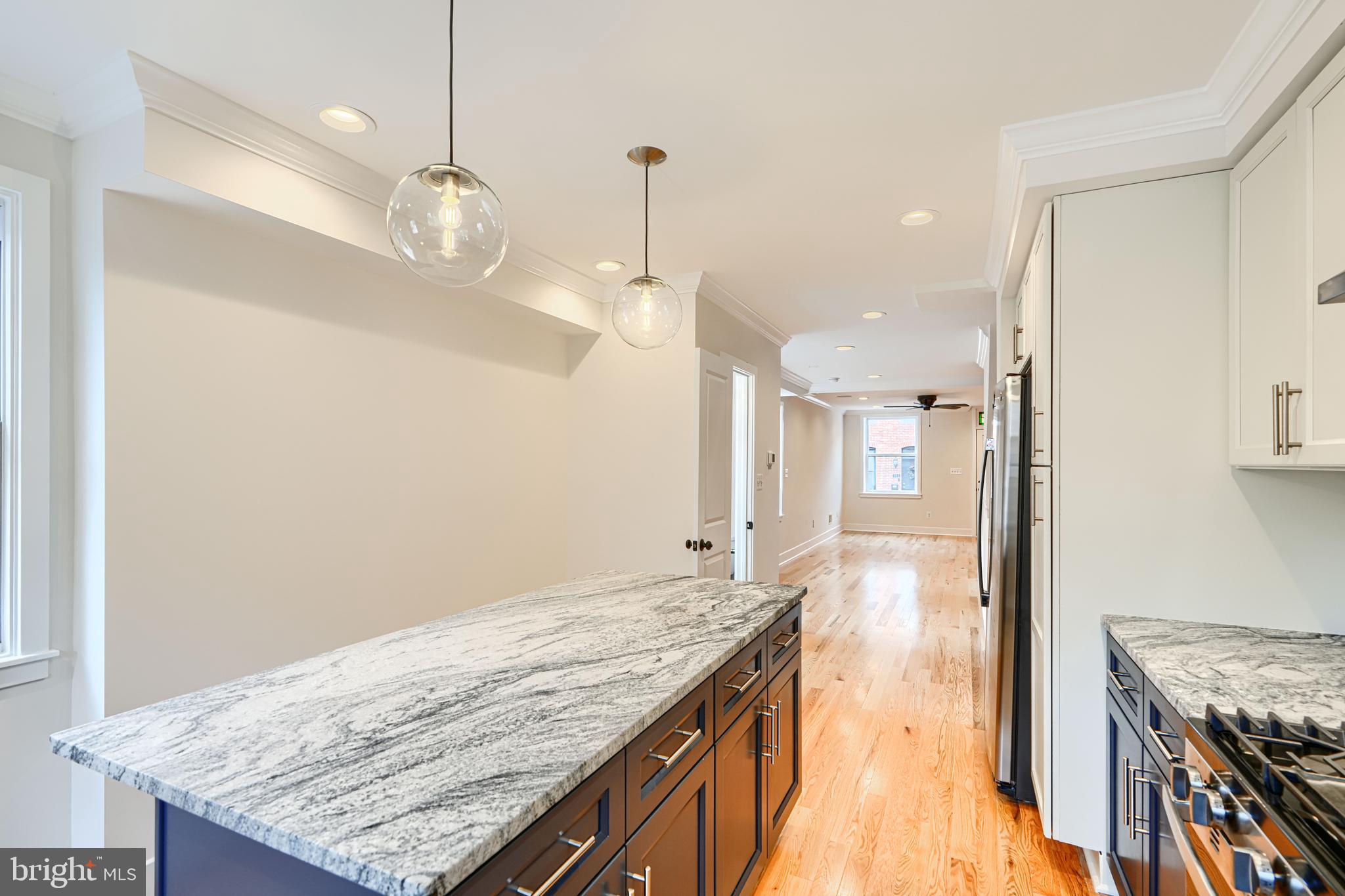 719 South Robinson Street Baltimore, MD 21224 - Photo 14 of 31 a kitchen with granite countertop wooden floor and a refrigerator