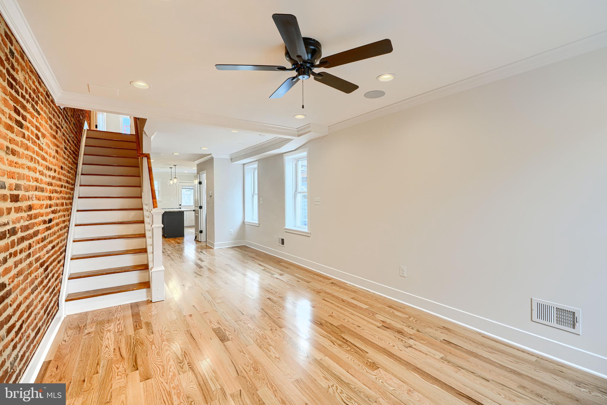 719 South Robinson Street Baltimore, MD 21224 - Photo 4 of 31 a view of an empty room with wooden floor and a ceiling fan