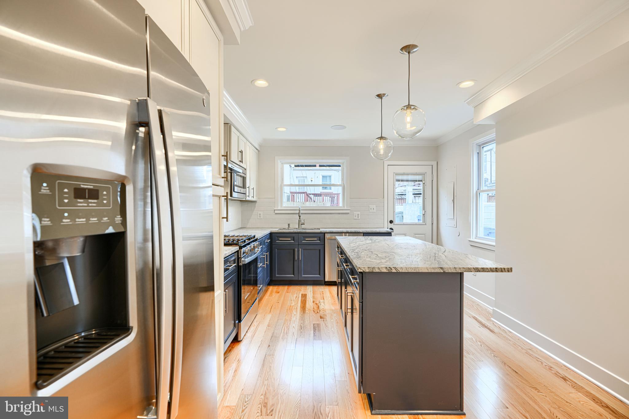 719 South Robinson Street Baltimore, MD 21224 - Photo 9 of 31 a kitchen with stainless steel appliances granite countertop a refrigerator a stove and a wooden floors
